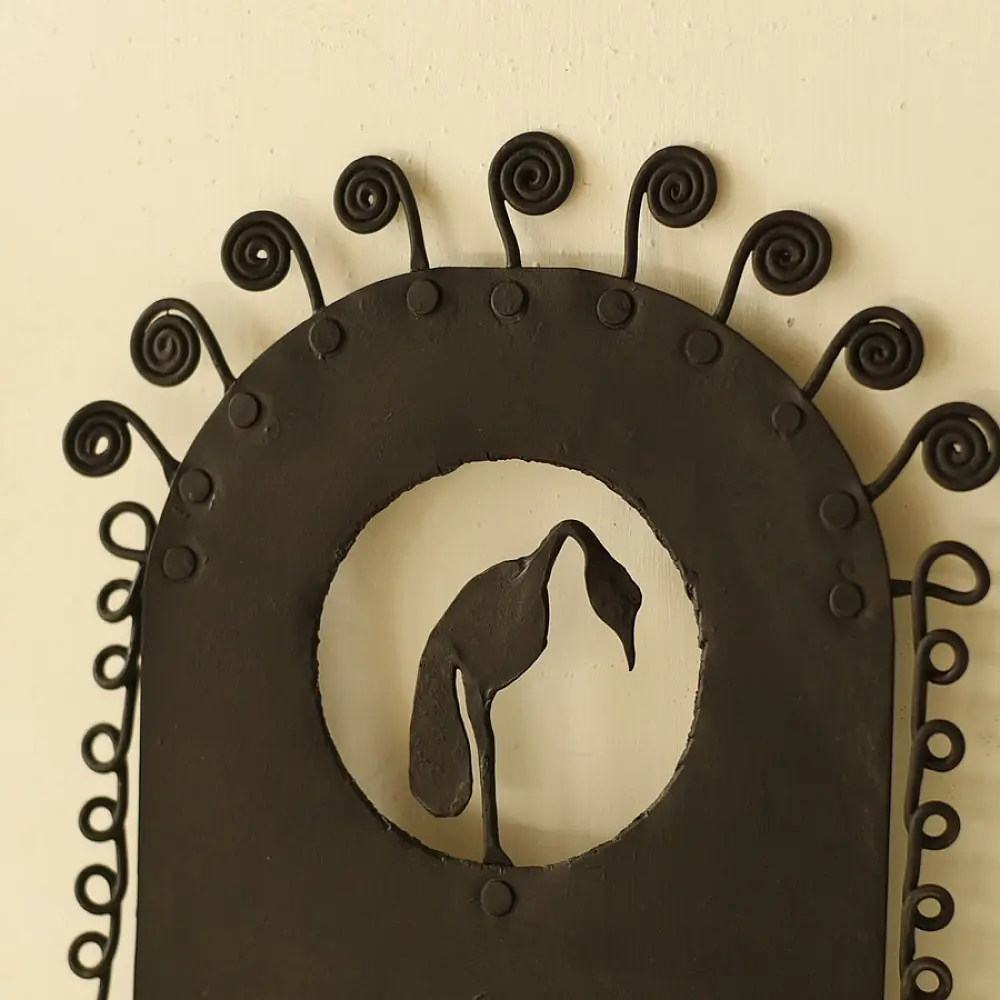 handcrafted black wrought iron wall hanging candle holder featuring a central circular cutout with a crane silhouette and an arched frame with spiral scrolls