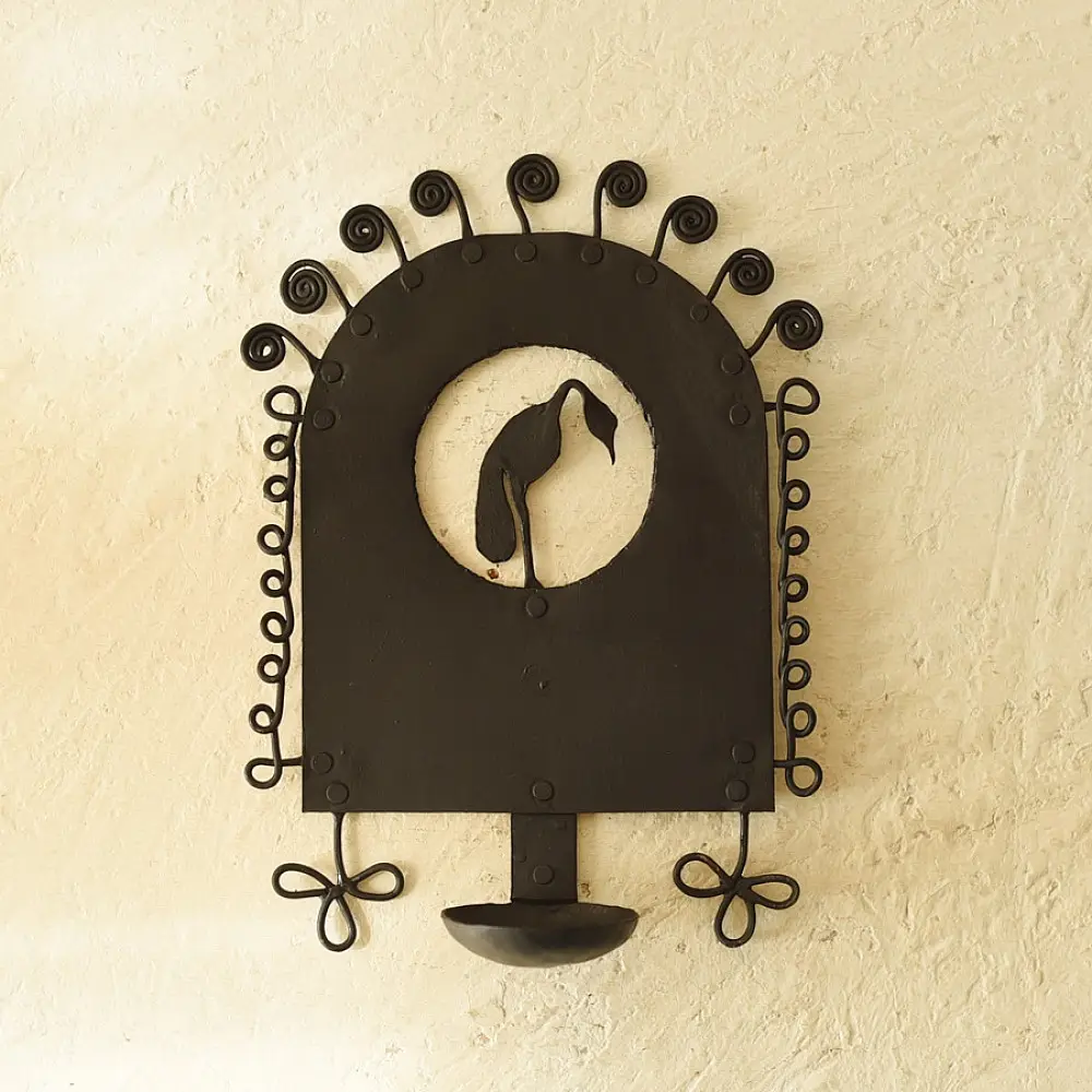 handcrafted black wrought iron wall hanging candle holder featuring a central circular cutout with a crane silhouette and an arched frame with spiral scrolls