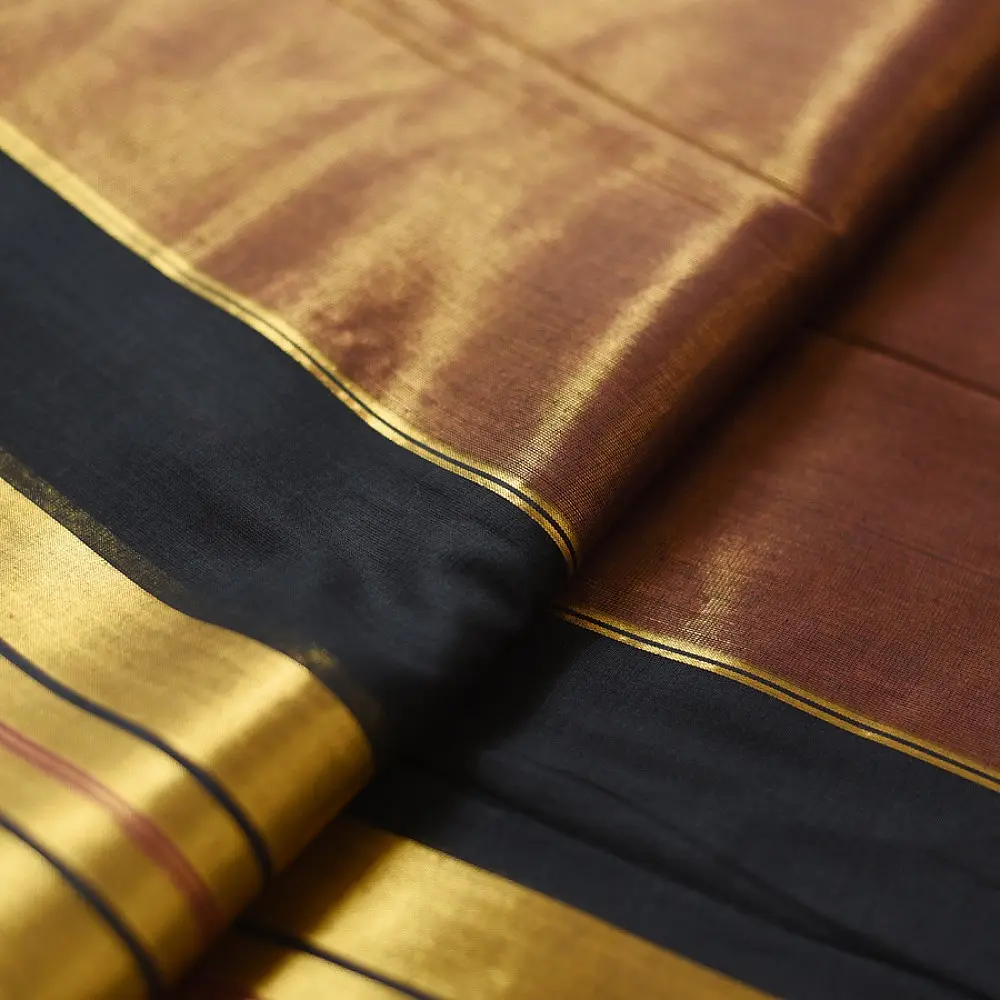 handloom pure cotton saree in deep rust orange with contrasting black border woven with metallic golden zari stripes and handcrafted tassels