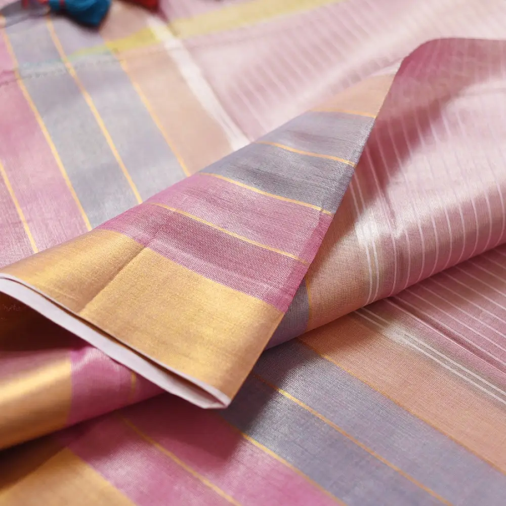 handloom pure cotton saree in soft baby pink featuring subtle fine stripes contrast woven zari border and handcrafted turquoise blue tassels on pallu