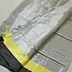 handloom pure cotton saree in soft grey and white featuring a bright lemon yellow color blocked panel with a black striped zari border and handcrafted tassels