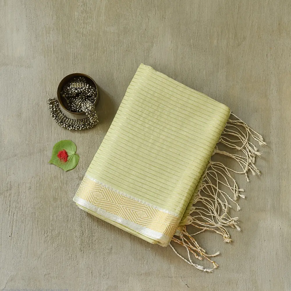 handloom pure cotton saree in subtle pista green featuring delicate fine stripes woven golden zari border and soft beige handcrafted tassels