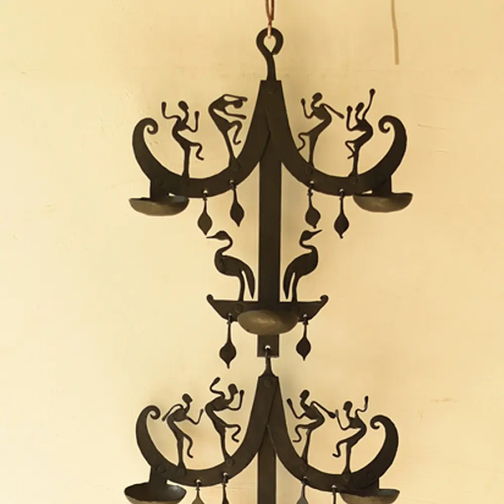 handcrafted black wrought iron wall hanging lamp featuring a tiered vertical chain design with stylized tribal figures and oil diya cups