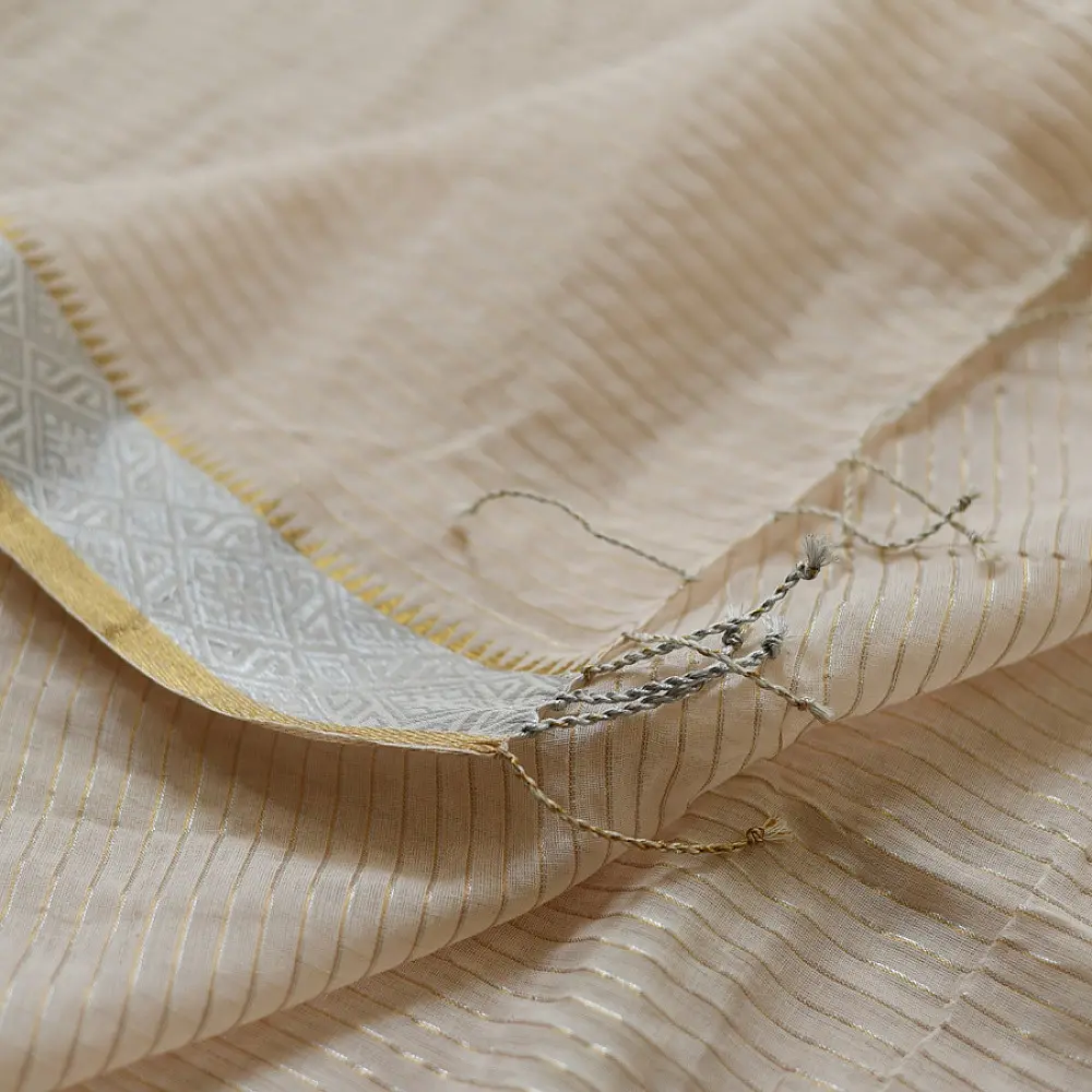 handloom pure cotton saree in luminous moti white featuring delicate micro stripes a woven gold zari border and soft handcrafted tassels