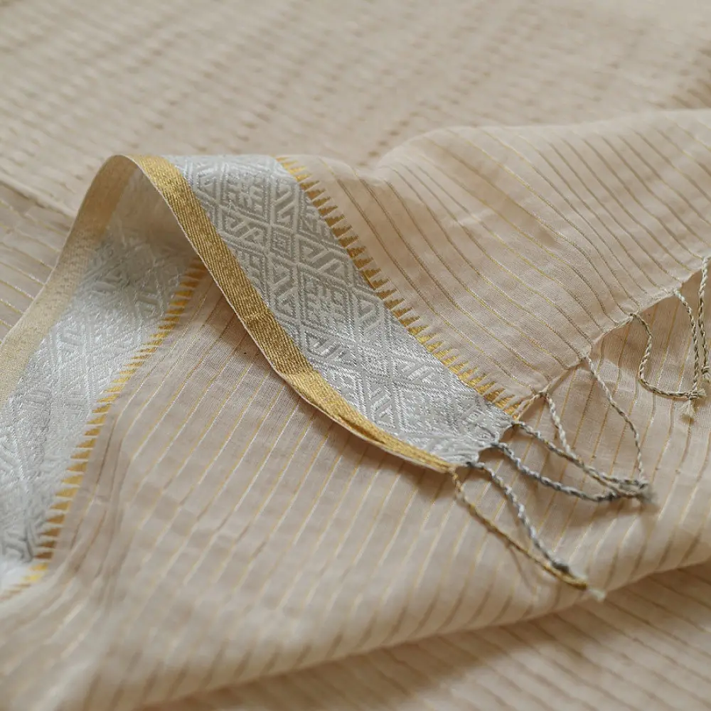 handloom pure cotton saree in luminous moti white featuring delicate micro stripes a woven gold zari border and soft handcrafted tassels