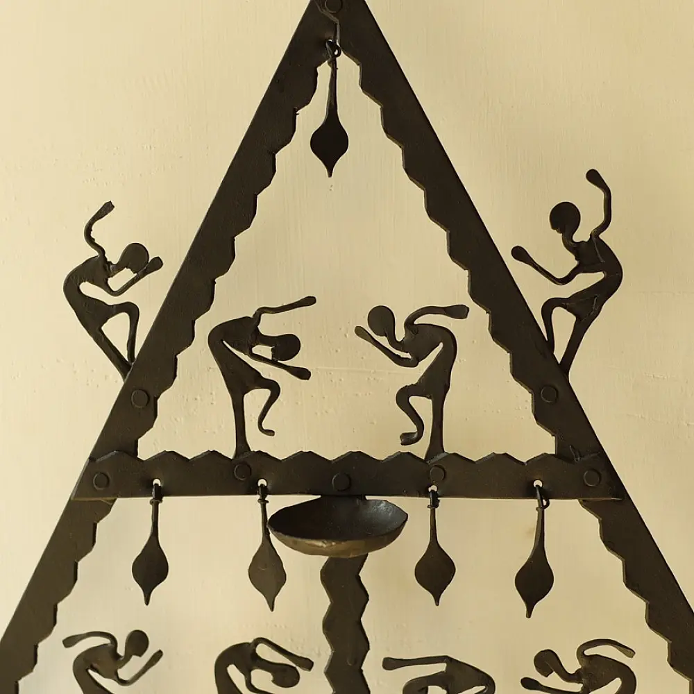 handcrafted black wrought iron triangular hanging lamp featuring multi-tier compartments with dancing tribal figures and hanging oil diya cups