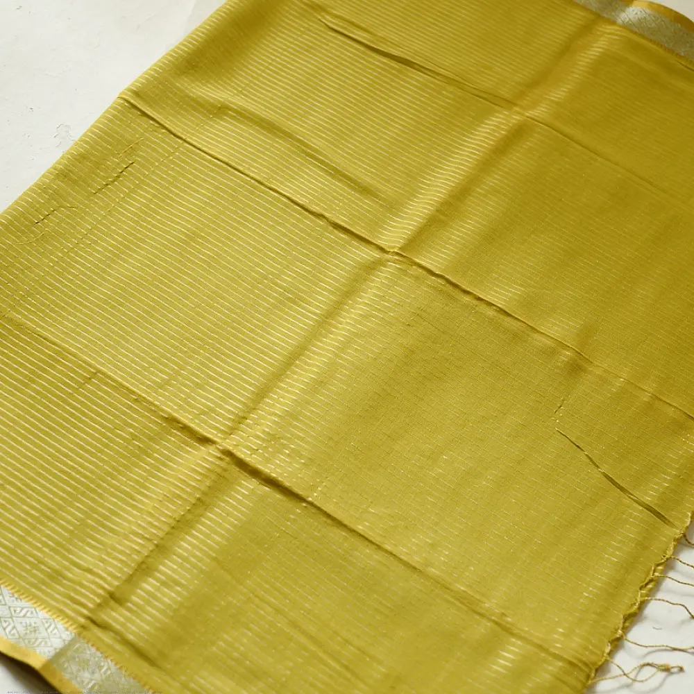 handloom pure cotton saree in subtle olivish mustard yellow featuring delicate micro stripes a woven silver zari border and soft beige handcrafted tassels