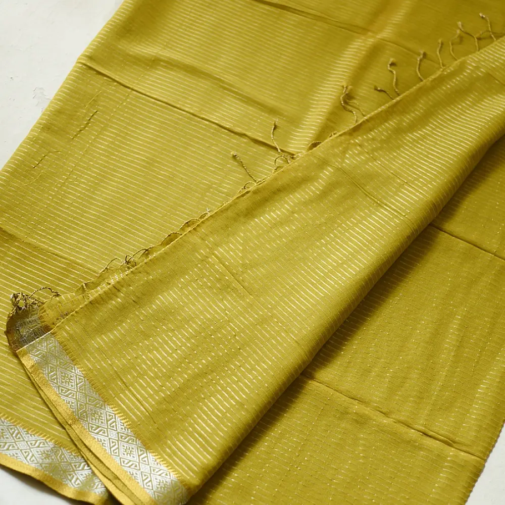 handloom pure cotton saree in subtle olivish mustard yellow featuring delicate micro stripes a woven silver zari border and soft beige handcrafted tassels