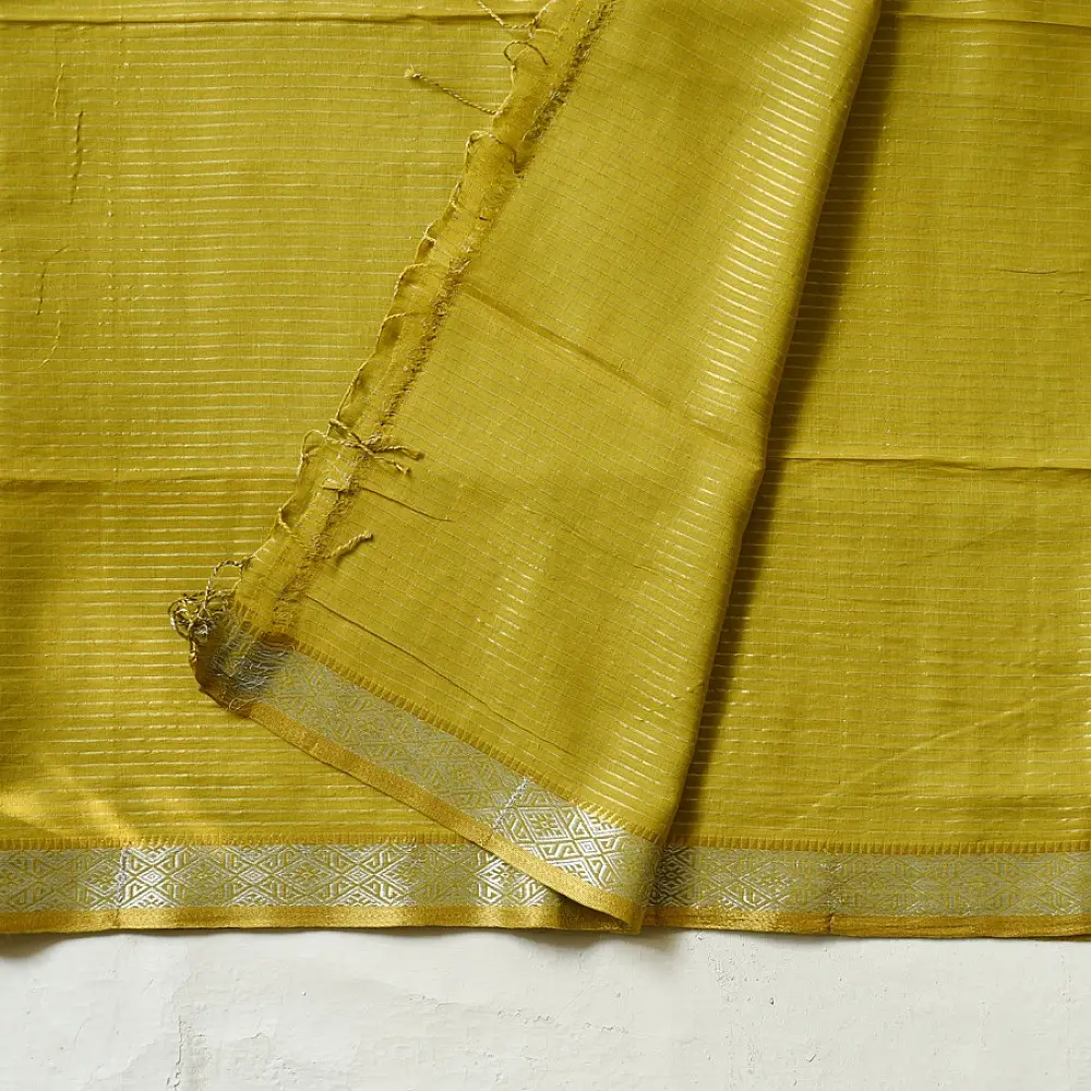 handloom pure cotton saree in subtle olivish mustard yellow featuring delicate micro stripes a woven silver zari border and soft beige handcrafted tassels