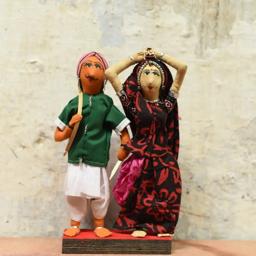 handcrafted tribal bhil fabric dolls featuring a traditional man in a green tunic and a woman carrying a pot in a maroon sari
