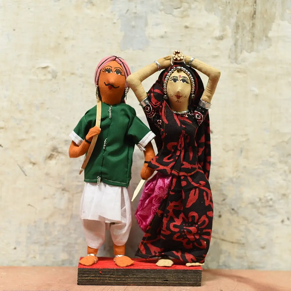handcrafted tribal bhil fabric dolls featuring a traditional man in a green tunic and a woman carrying a pot in a maroon sari