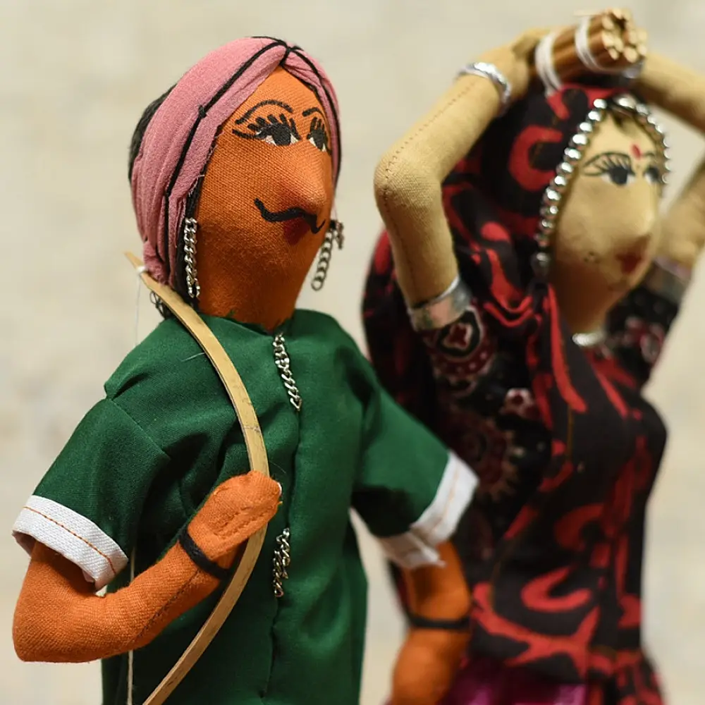 handcrafted tribal bhil fabric dolls featuring a traditional man in a green tunic and a woman carrying a pot in a maroon sari