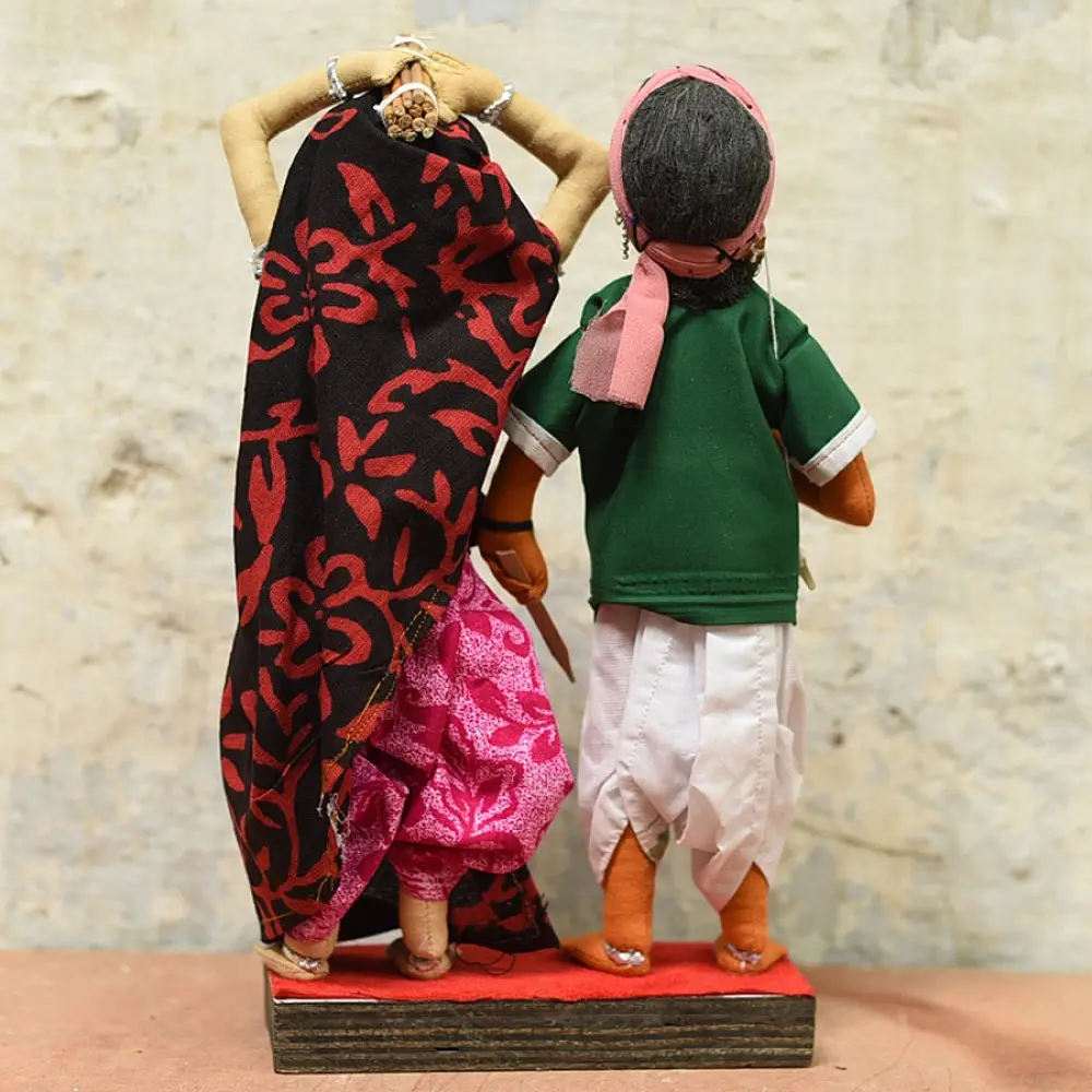handcrafted tribal bhil fabric dolls featuring a traditional man in a green tunic and a woman carrying a pot in a maroon sari