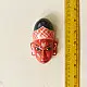 handcrafted hand painted red wooden mask of sugriva with a crosshatched headgear and tilak mark from west bengal