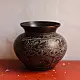 handmade antique dark brass lota with engraved peacock and geometric motifs used as a decorative vessel