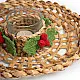 handcrafted banana fiber woven candle wreath centerpiece with a glass tealight holder cup and green and red crochet holly berry accents on a dining table layout