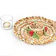 handcrafted banana fiber woven candle wreath centerpiece with a glass tealight holder cup and green and red crochet holly berry accents on a dining table layout