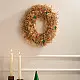 handcrafted banana fiber frill circular christmas wreath accented with miniature red and green star decorations against a neutral background wall
