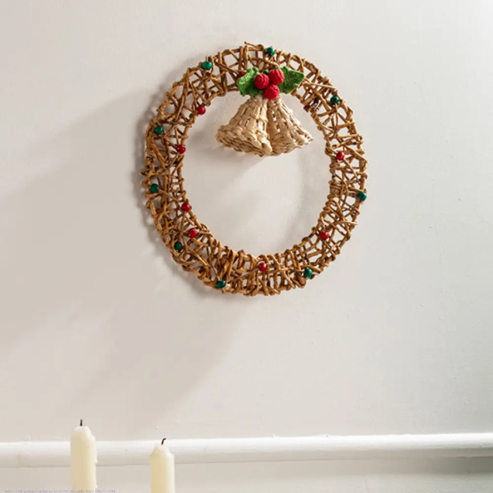 handcrafted circular banana rope woven christmas wreath featuring suspended center bells and red and green crochet holly berry accents