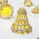 handcrafted banana bark fiber bell fairy lights emitting a warm amber glow against a textured white brick wall pattern