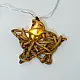 handcrafted banana fiber rope star fairy lights emitting a warm amber glow against a textured white brick wall pattern