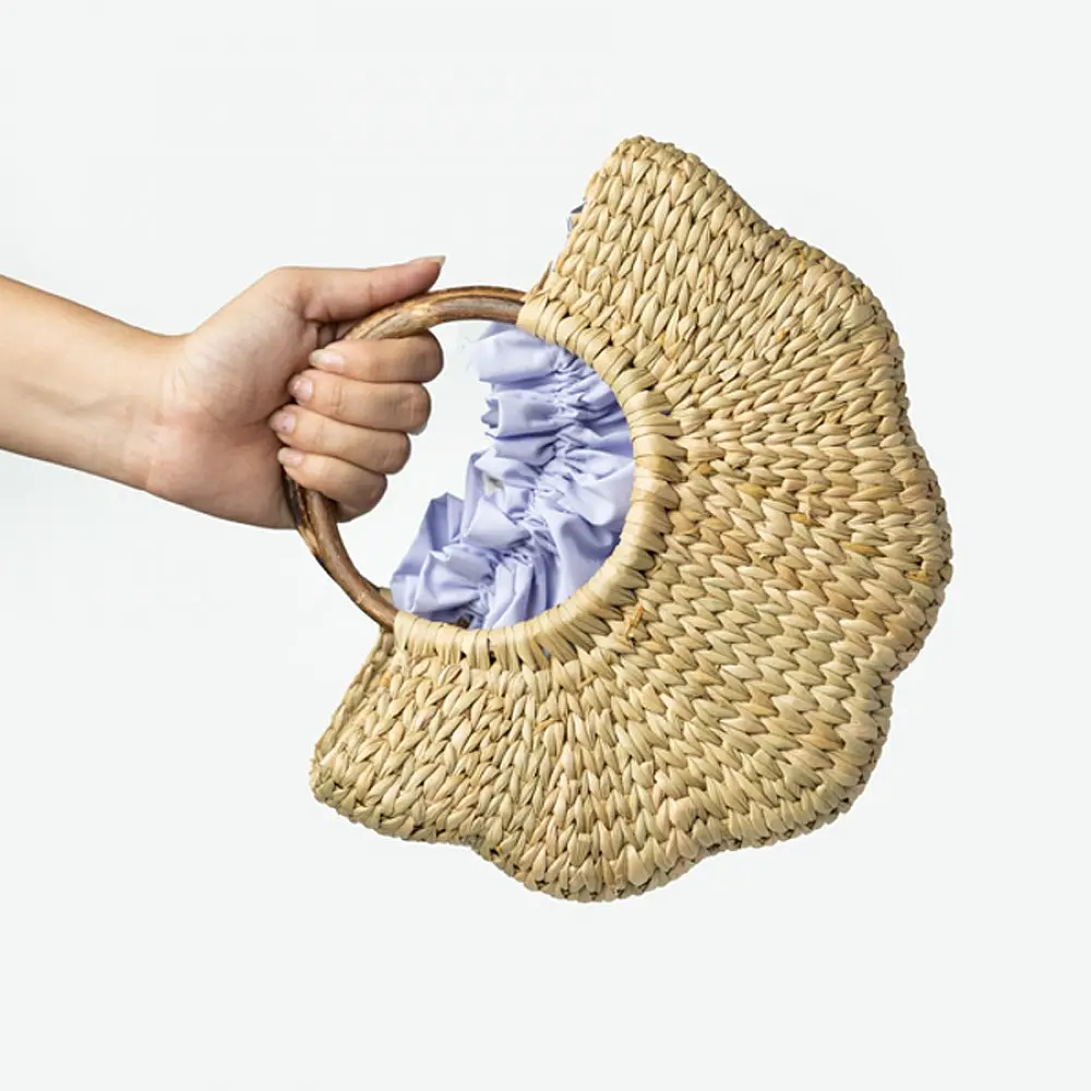 Natural handcrafted water reed handbag with a woven texture, rounded handles and a spacious fabric-lined interior