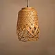 handcrafted woven bamboo twirl pendant light emitting a warm golden glow on a brown background wall