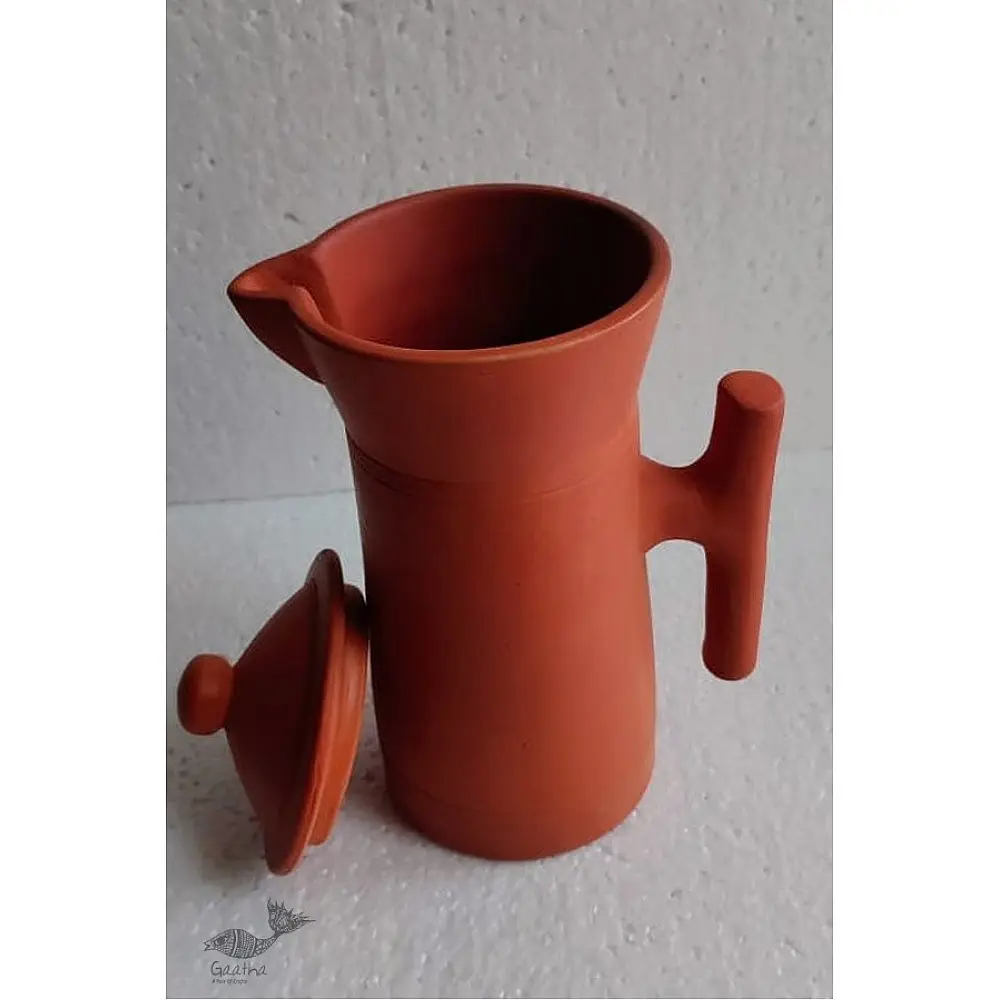 terracotta clay designer jug with fitted lid and curved handle in natural earthy tone