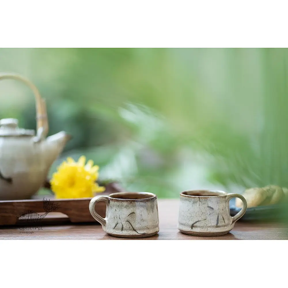 handmade studio ceramic tea cups set of two in light beige brown speckled glaze with hand painted minimal leaf art