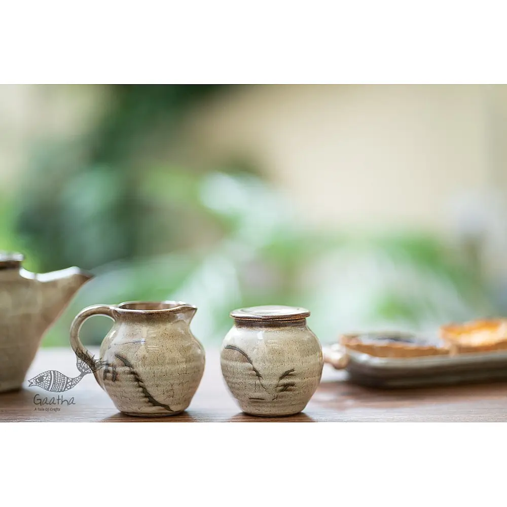 off-white and brown ceramic sugar pot and milk jug set with hand-painted swirl motif