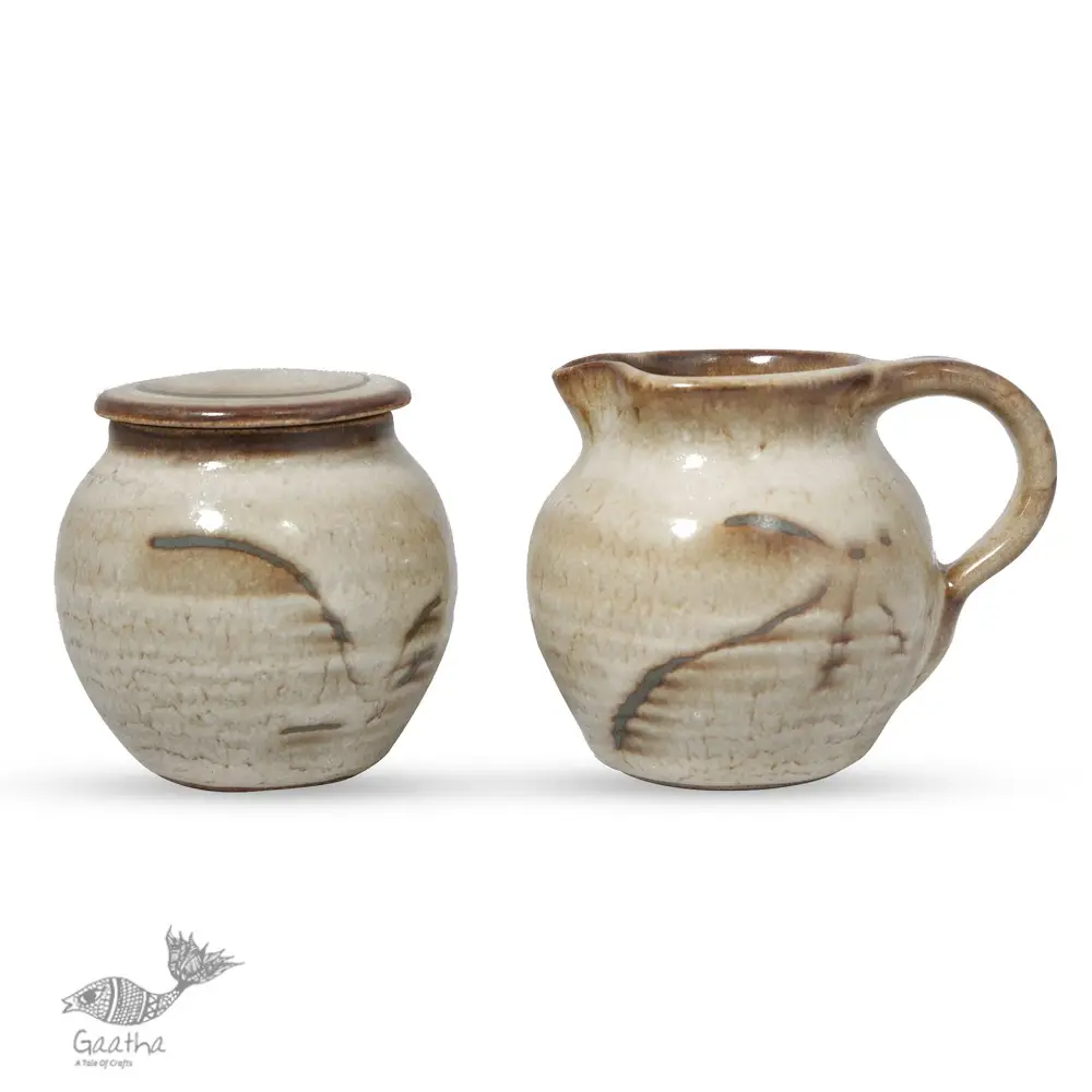off-white and brown ceramic sugar pot and milk jug set with hand-painted swirl motif