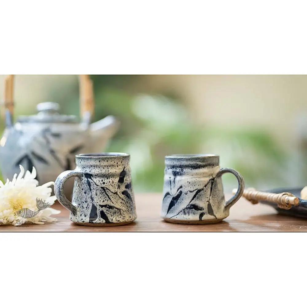 handmade studio ceramic coffee mugs set of two in light blue and white glaze with hand painted botanical leaf motifs