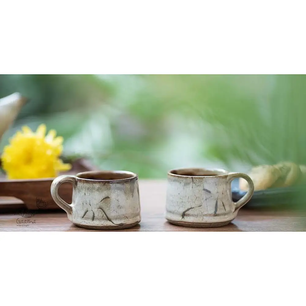 handmade studio ceramic tea cups set of two in light beige brown speckled glaze with hand painted minimal leaf art