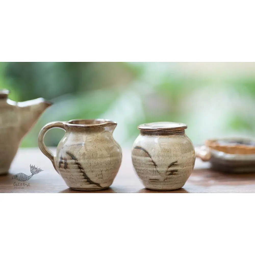 off-white and brown ceramic sugar pot and milk jug set with hand-painted swirl motif