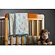 blue fog block printed baby dohar blanket with whimsical monkey and bananas pattern draped over a crib