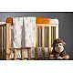 peach apricot block printed baby dohar blanket with whimsical monkey and bananas pattern draped over a crib