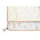peach apricot block printed baby dohar blanket with whimsical monkey and bananas pattern draped over a crib