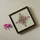handcrafted square wooden box featuring an ivory fabric top panel with multi-color geometric Soof hand embroidery next to pink flowers