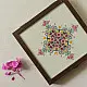 handcrafted square wooden box featuring an ivory fabric top panel with multi-color geometric Soof hand embroidery next to pink flowers