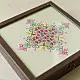 handcrafted square wooden box featuring an ivory fabric top panel with multi-color geometric Soof hand embroidery next to pink flowers