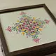 handcrafted square wooden box featuring an ivory fabric top panel with multi-color geometric Soof hand embroidery next to pink flowers