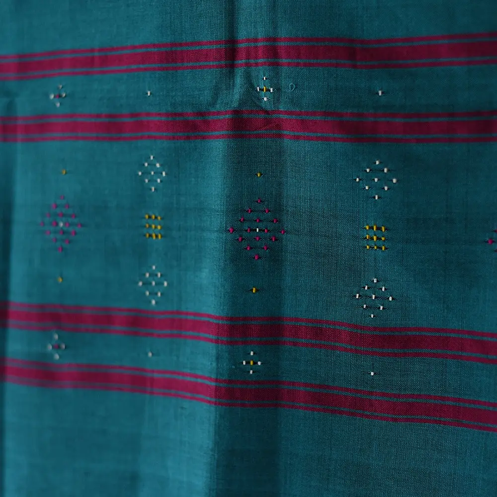 tangaliya handloom cotton stole in ocean teal blue with maroon red stripes, yellow and white raised dana bead motifs, and hand-knotted fringe tassels