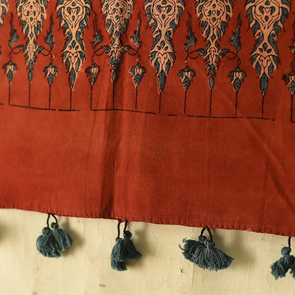 terracotta madder red indigo blue ajrakh cotton stole hand block printed floral sprig body ornate circular mandala border traditional mihrab arched detail artisanal scarf sustainable fashion natural dyed with tassels