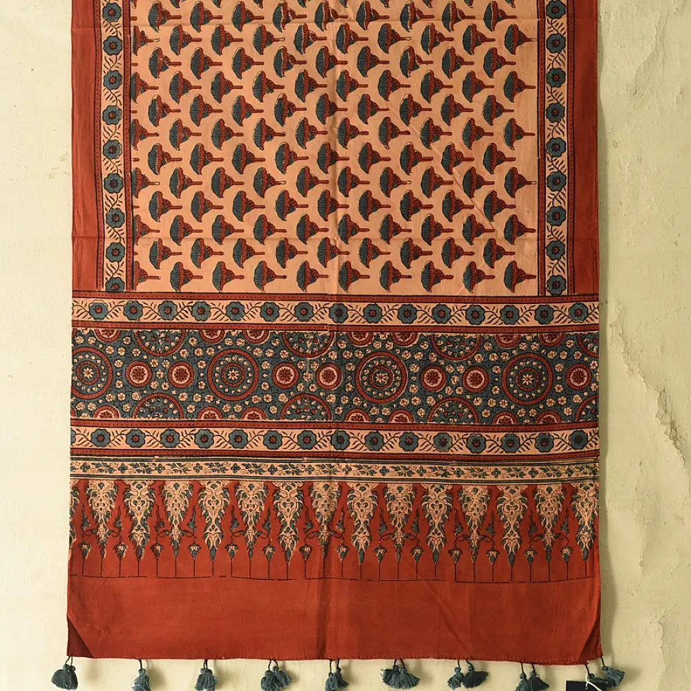 terracotta madder red indigo blue ajrakh cotton stole hand block printed floral sprig body ornate circular mandala border traditional mihrab arched detail artisanal scarf sustainable fashion natural dyed with tassels