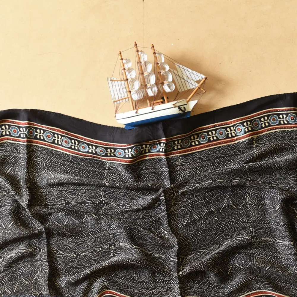 black gold ajrakh cotton stole hand block printed bundi tiny dot body ornate circular mandala border traditional mihrab arched detail artisanal scarf sustainable fashion natural dyed with tassels