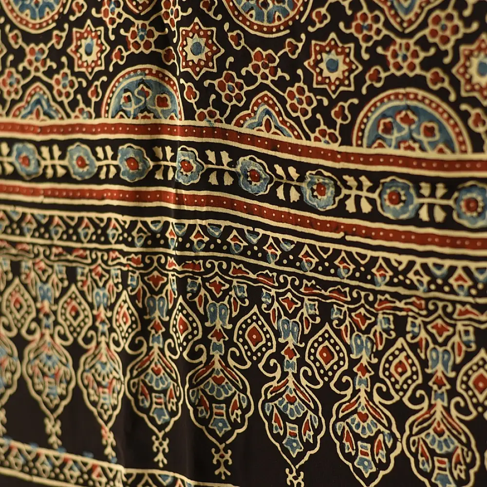black gold ajrakh cotton stole hand block printed bundi tiny dot body ornate circular mandala border traditional mihrab arched detail artisanal scarf sustainable fashion natural dyed with tassels