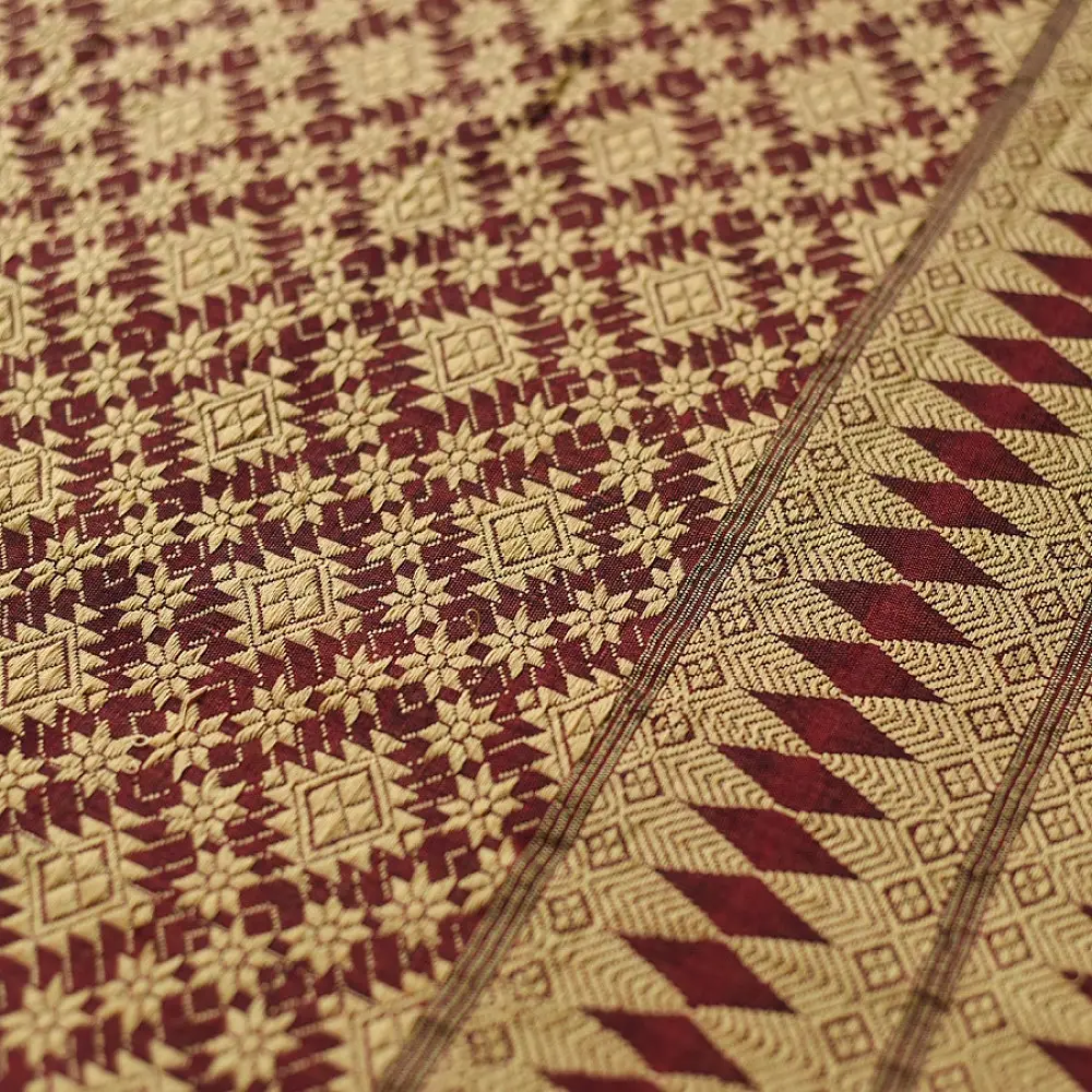 maroon red handloom traditional assam cotton saree with small gold star butta motifs and triangular border weaves for women