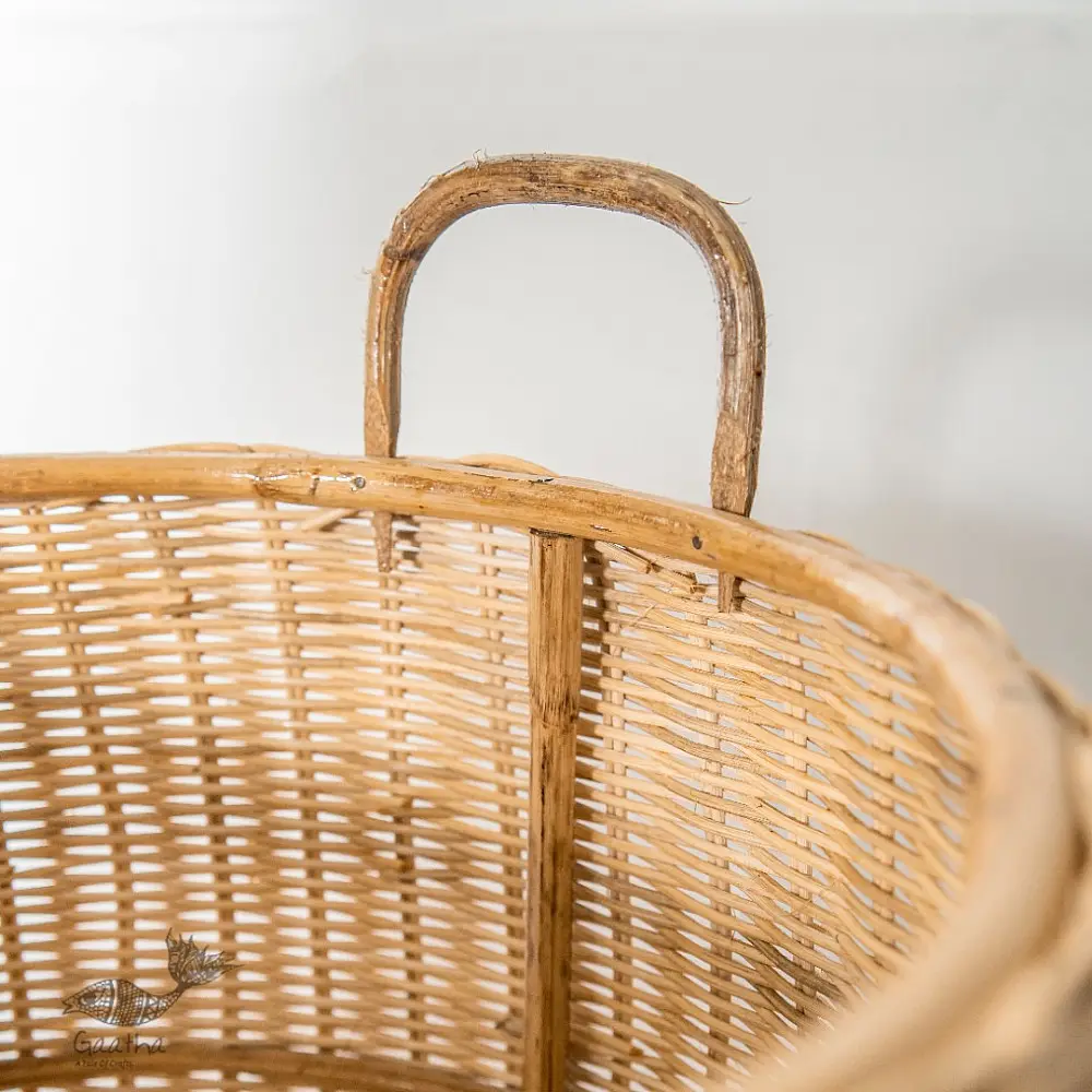 handmade natural wicker laundry basket with sturdy loop handles and woven cane texture