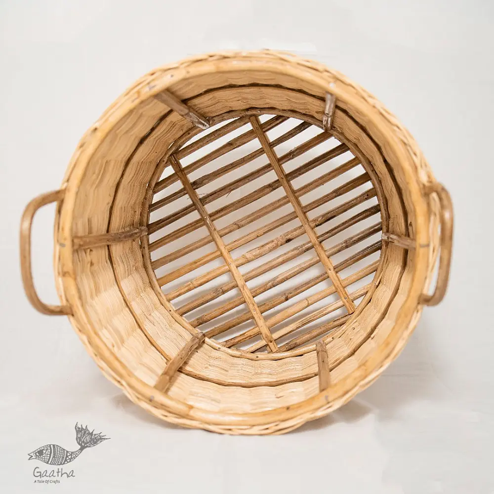 handmade natural wicker laundry basket with sturdy loop handles and woven cane texture