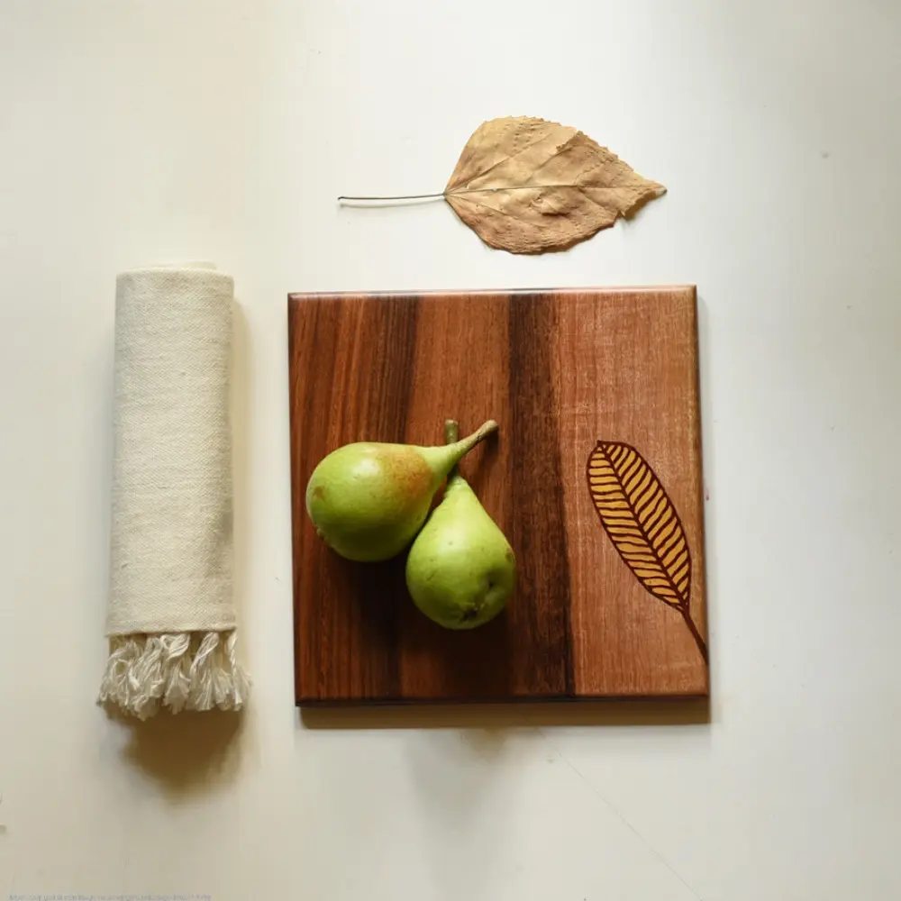 handmade wooden trivet with engraved leaf motif and two-tone finish